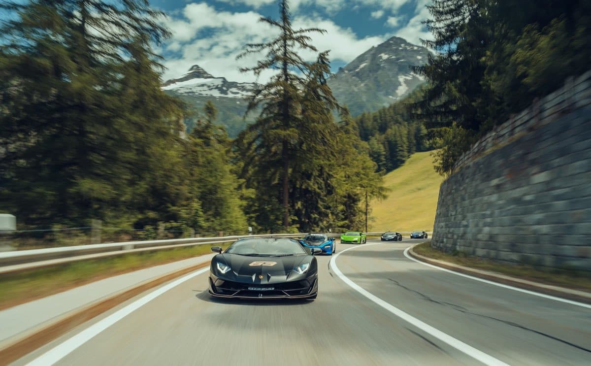 Sports cars running a mountain pass road on a driving tour